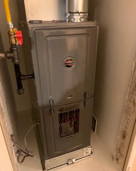 Rheem gas furnace installed in a closet with its gas line